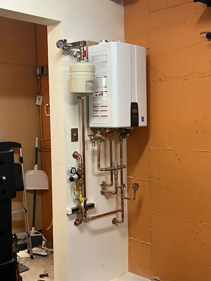 Plumbing technician inspecting water heater connections in Riverton